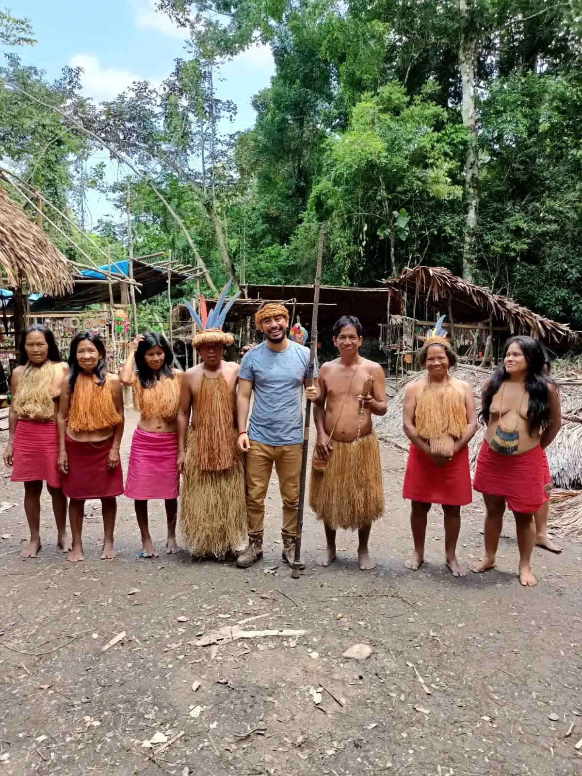 Visitante con integrantes de una comunidad yagua frente a sus malocas