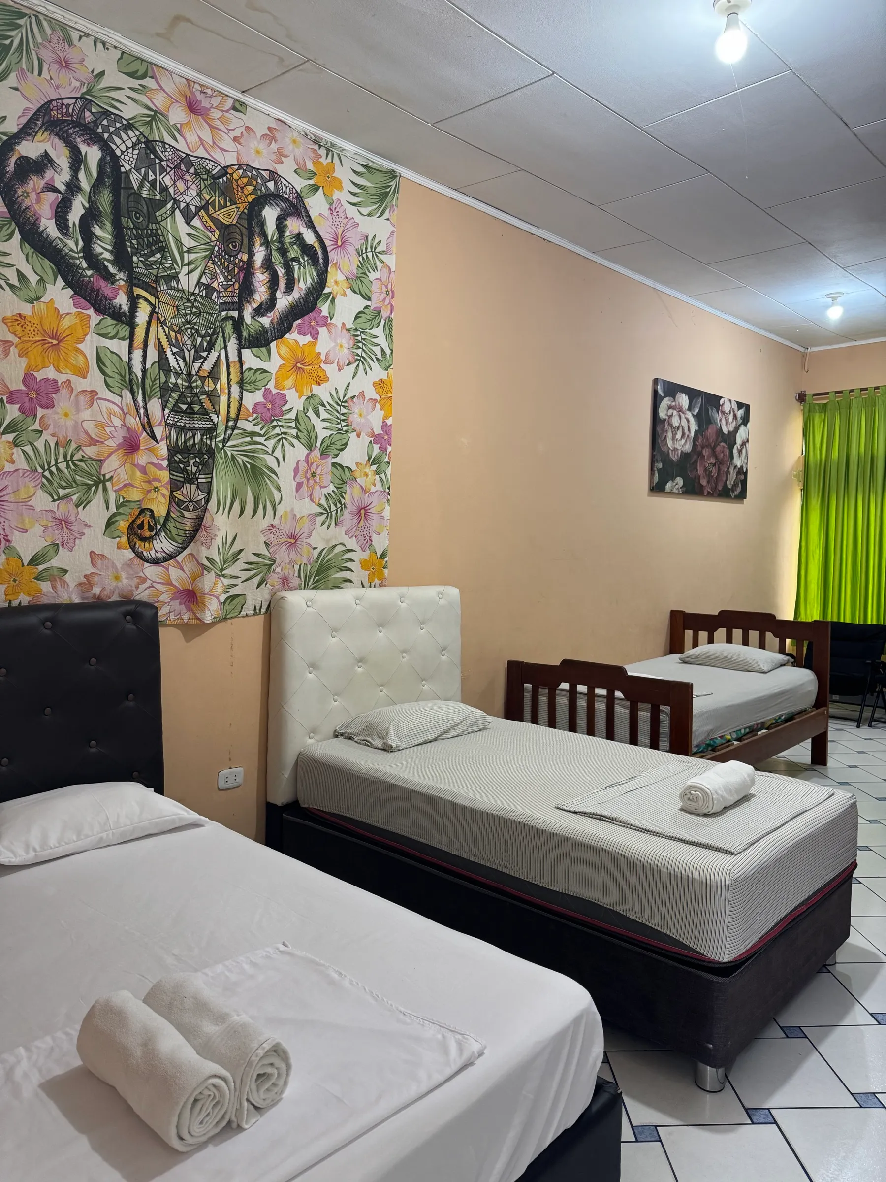 Habitación Triple con tres camas y mural de un elefante en la pared